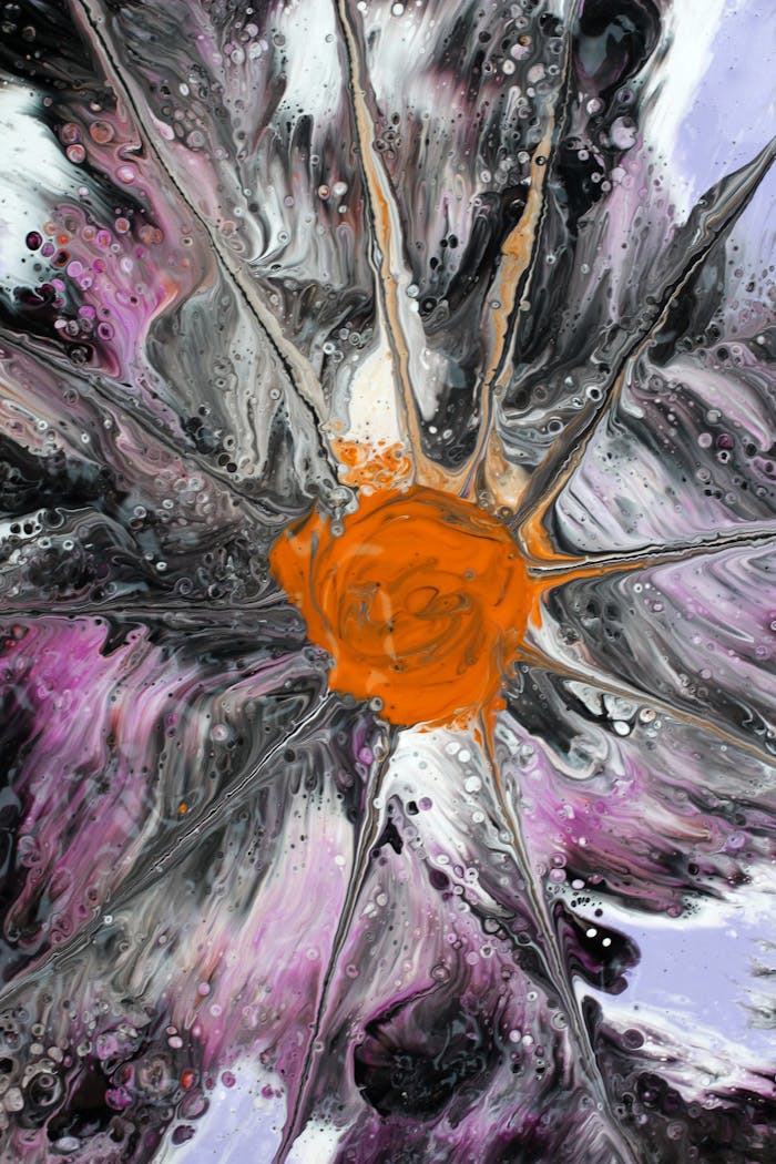 Dynamic abstract acrylic pour art with vivid orange and purple colors, radiating from the center.