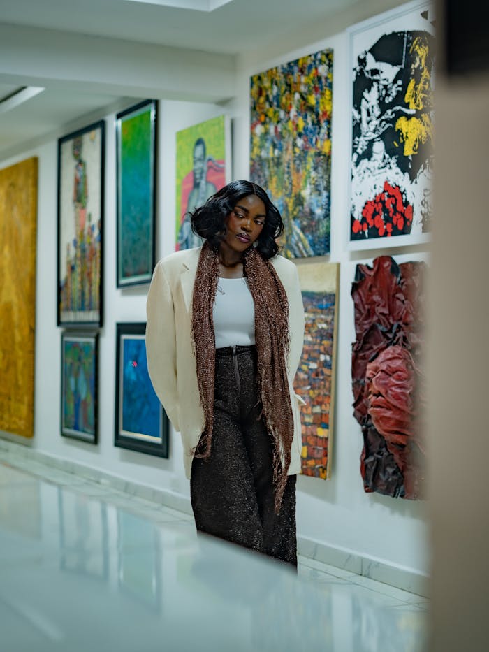 A woman explores a modern art gallery, surrounded by vibrant and diverse artwork.